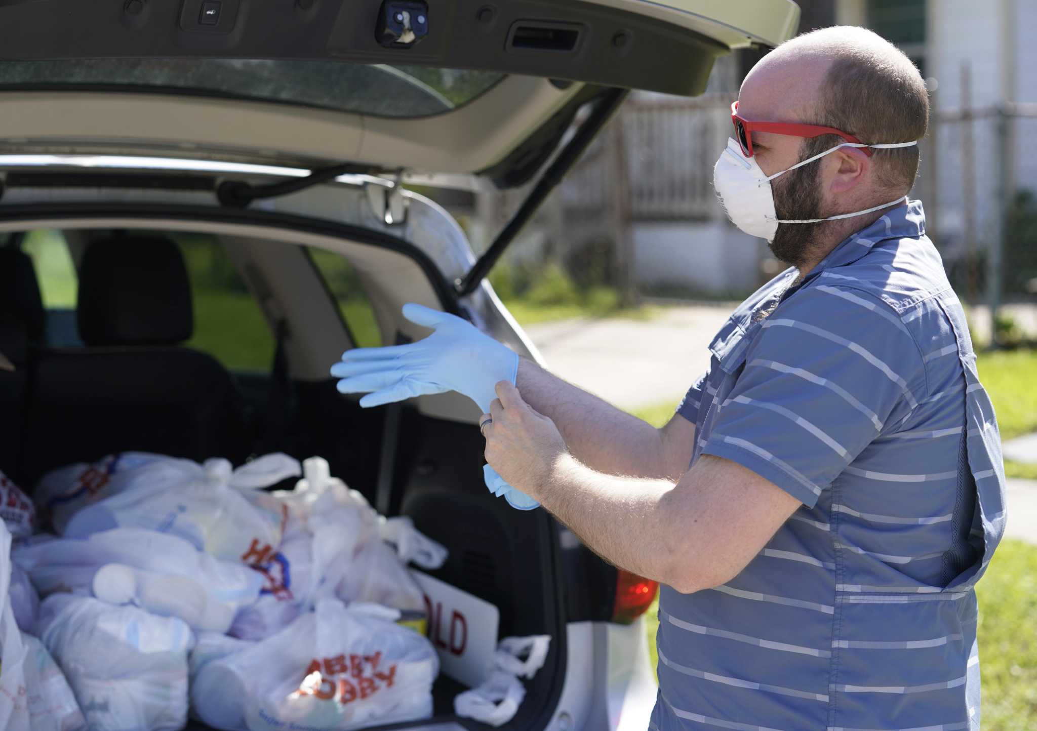 Picture of volunteer delivering food with mask and gloves on